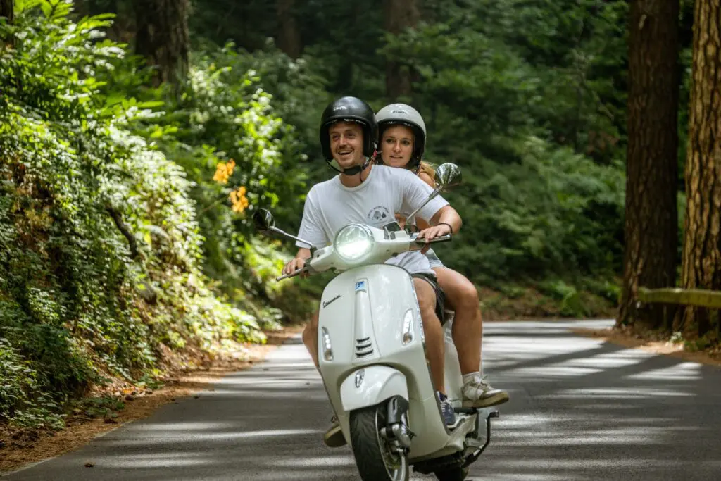 Paar, das während einer Vespa-Tour in Amalfi mit einer Vespa fährt.