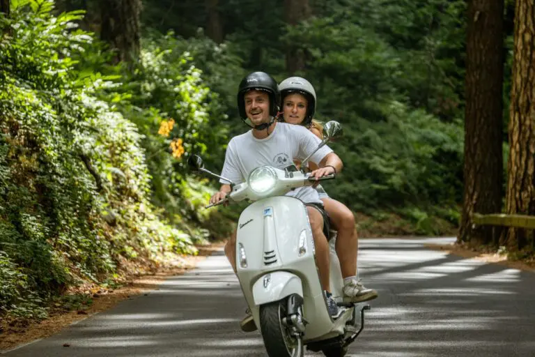 Paar, das während einer Vespa-Tour in Amalfi mit einer Vespa fährt.