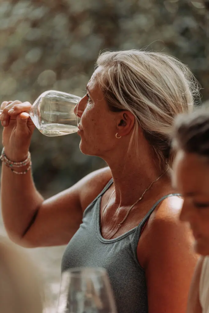 Eine Frau, die toskanischen Weißwein trinkt, während sie Wein in der Chianti-Region probiert.