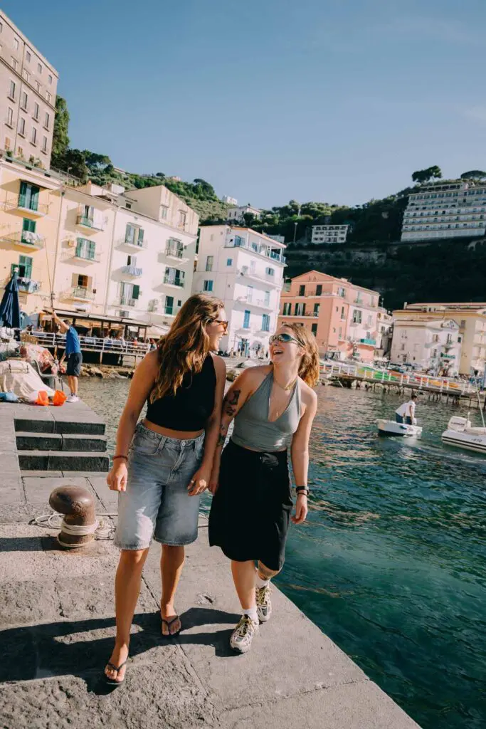 zwei Frauen, die auf einem Steg in einem italienischen Küstendorf lachen