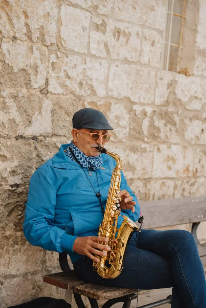 Mann, der in Apulien auf einer Bank Saxofon spielt