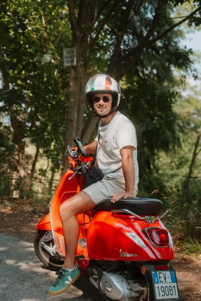 Mann auf roter Vespa in Venetien, Italien