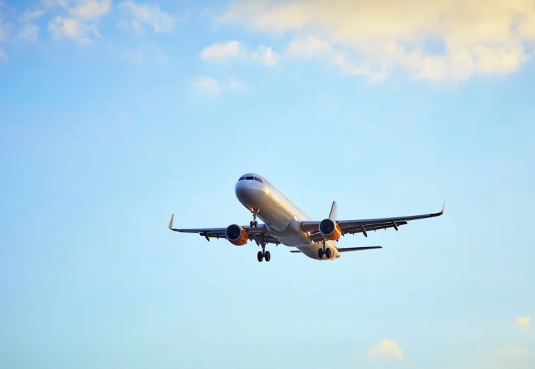 airplane taking off against a blue sky with clouds